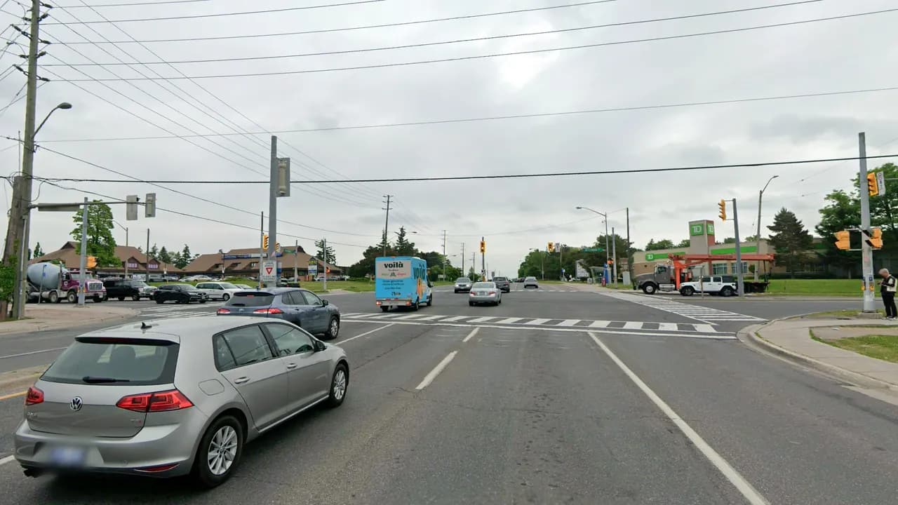 Highway 7 heading east at McCowan Road in Markham, with the crosswalk, traffic lights and a plaza on the far corner
