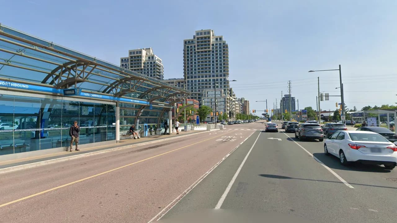 Yonge Street heading south toward 16th Avenue in Richmond Hill, with the glass Viva station in the middle of the road, red bus lanes beside it and condo towers ahead